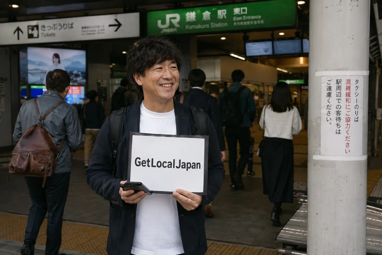 Local host waiting with a GetLocalJapan sign at a station