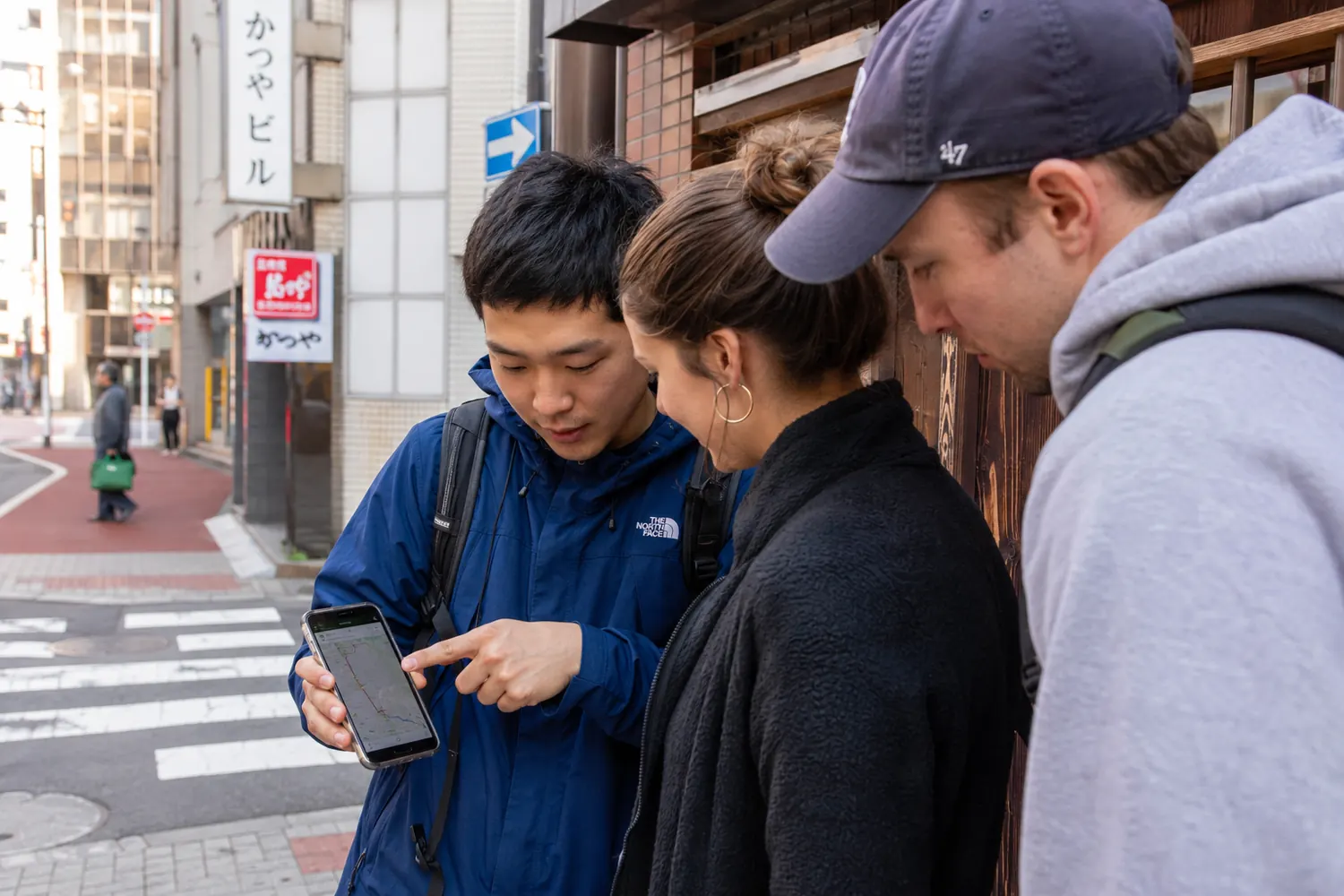 Host showing travelers the route on a phone