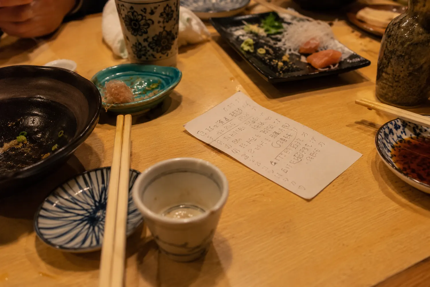Izakaya table with small dishes and handwritten notes