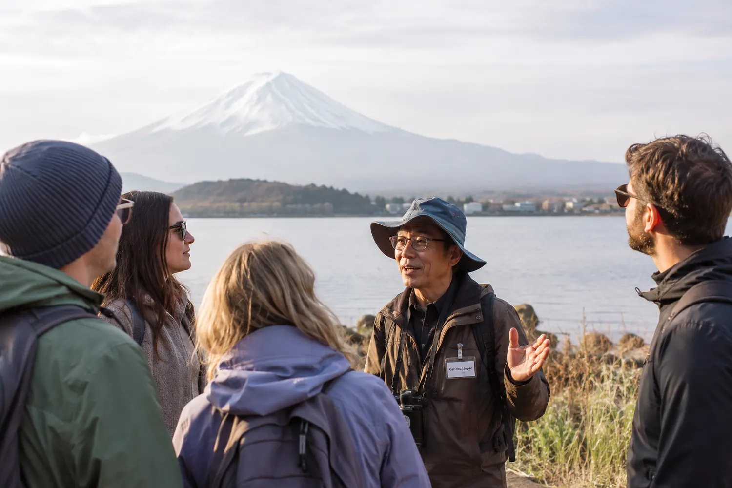 A local guide showing travelers Mount Fuji from a quiet lake